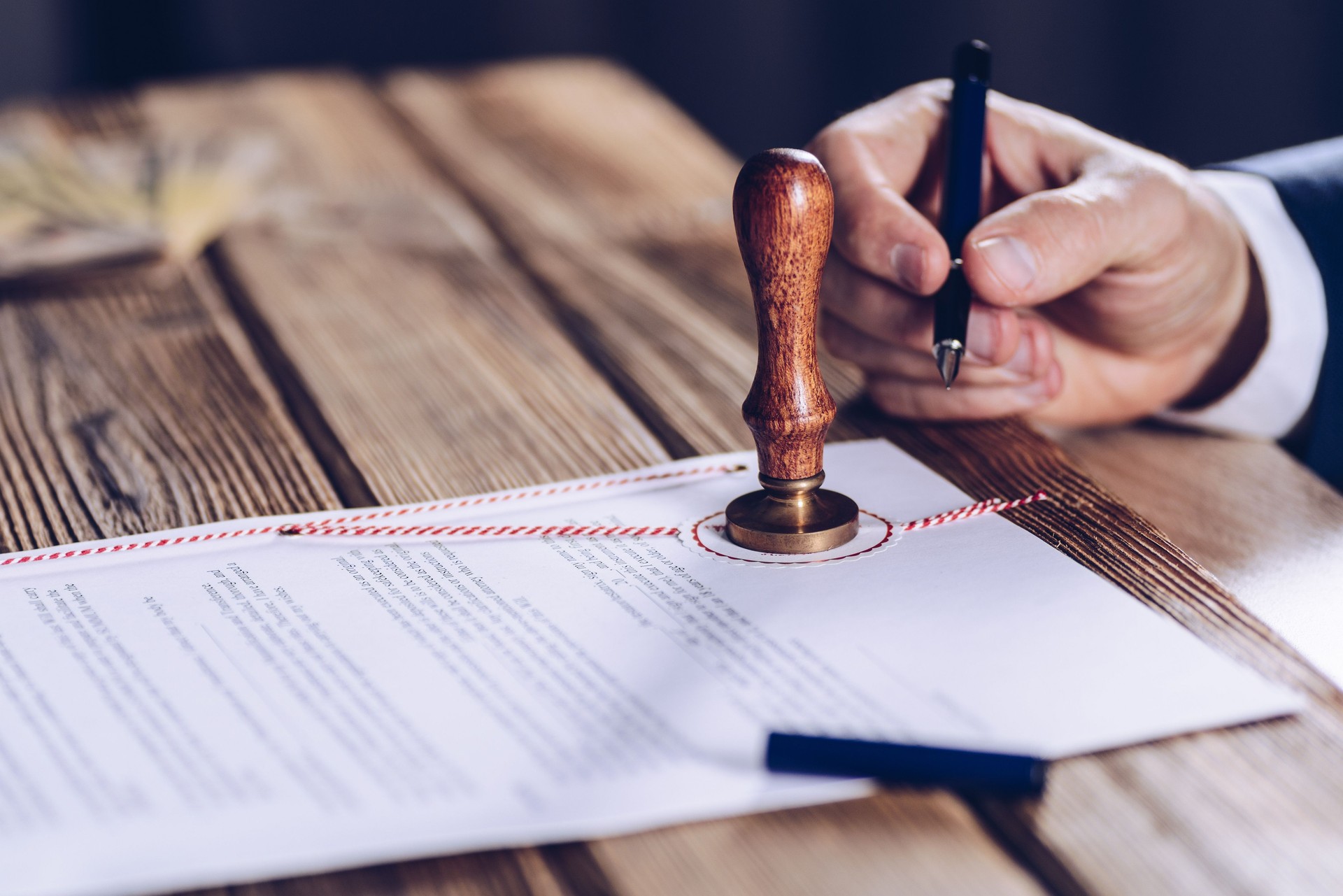 Male lawyer or notary signing document at his office.