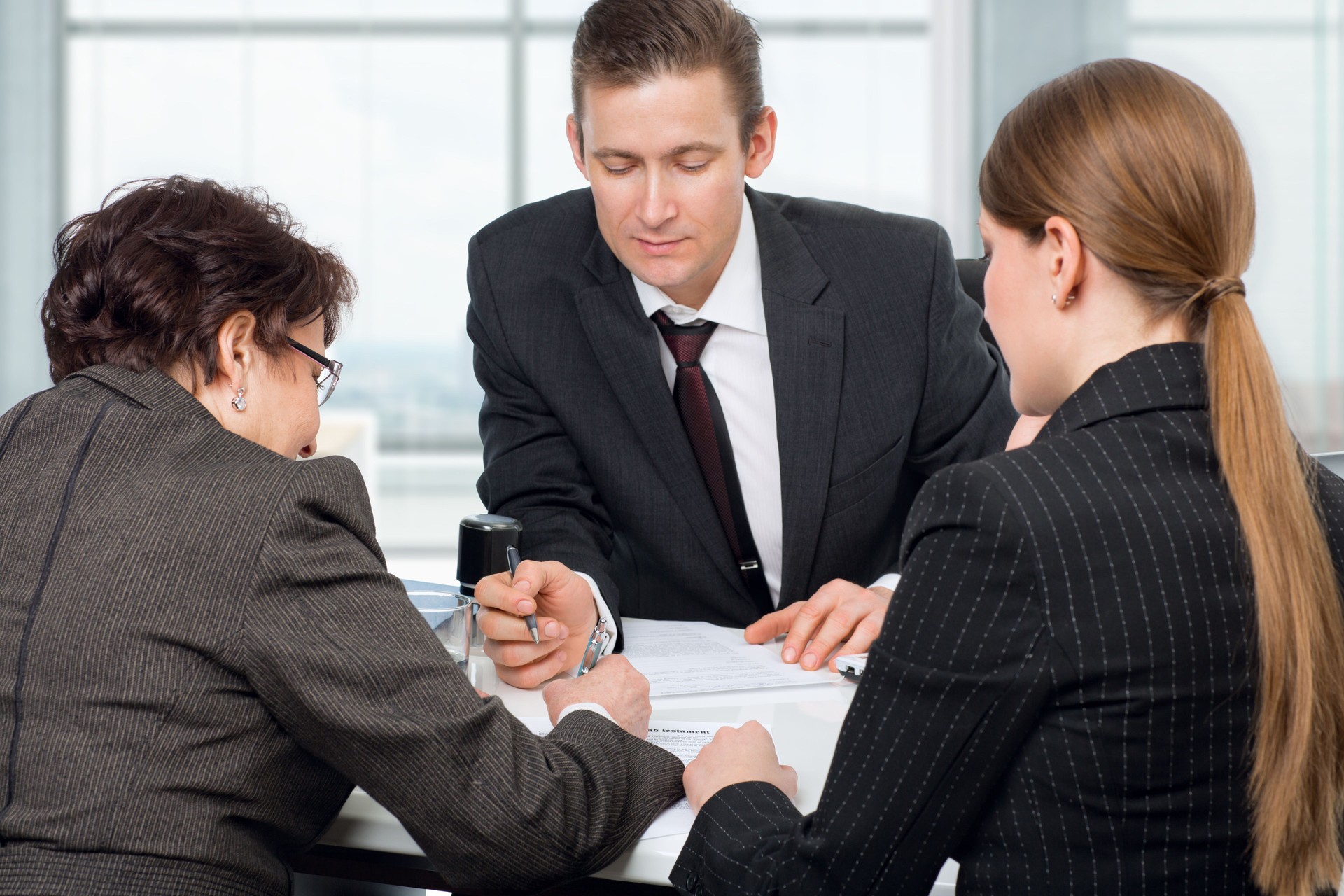 Agent signing documents with couple women